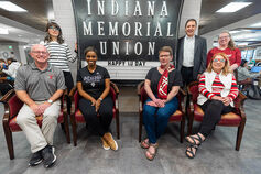 A groupd of students & staff pose in front of a Indiana Memorial Union sign.